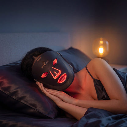 Woman wearing SkinMirae LED face mask in UAE with red light therapy activated for anti-aging results